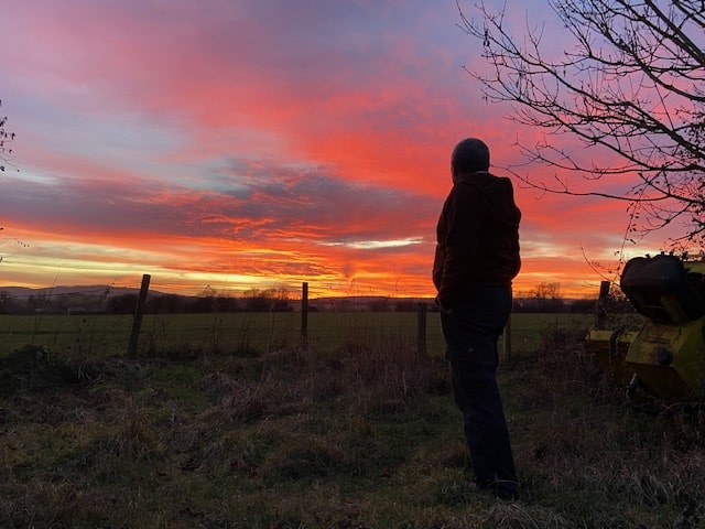 silhouette of man looking red sky sunset